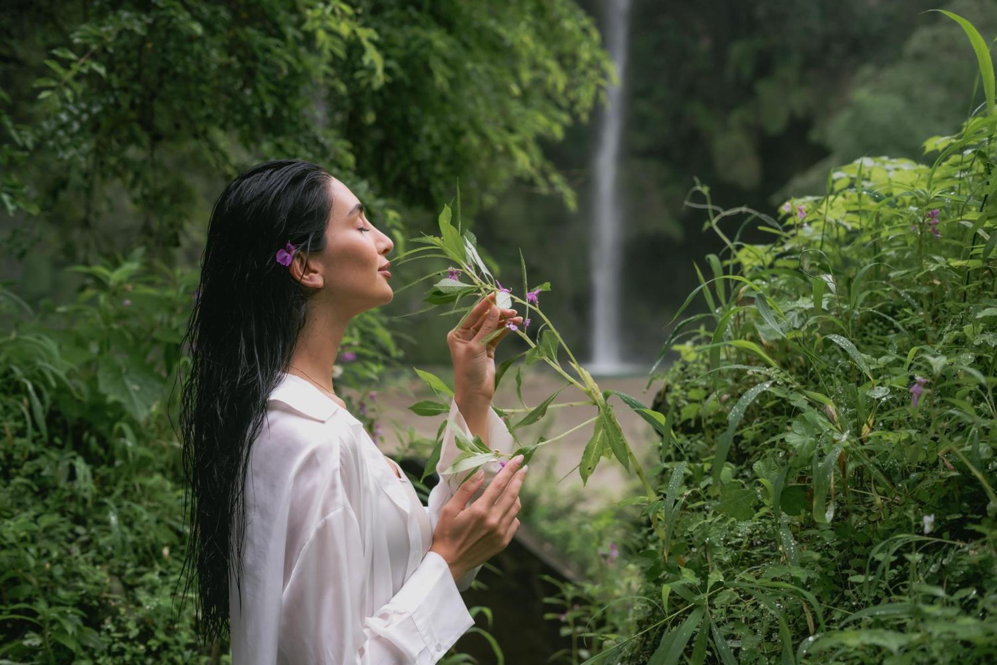 Salalah Rotana Resort Eksteriør billede A woman smelling flowers